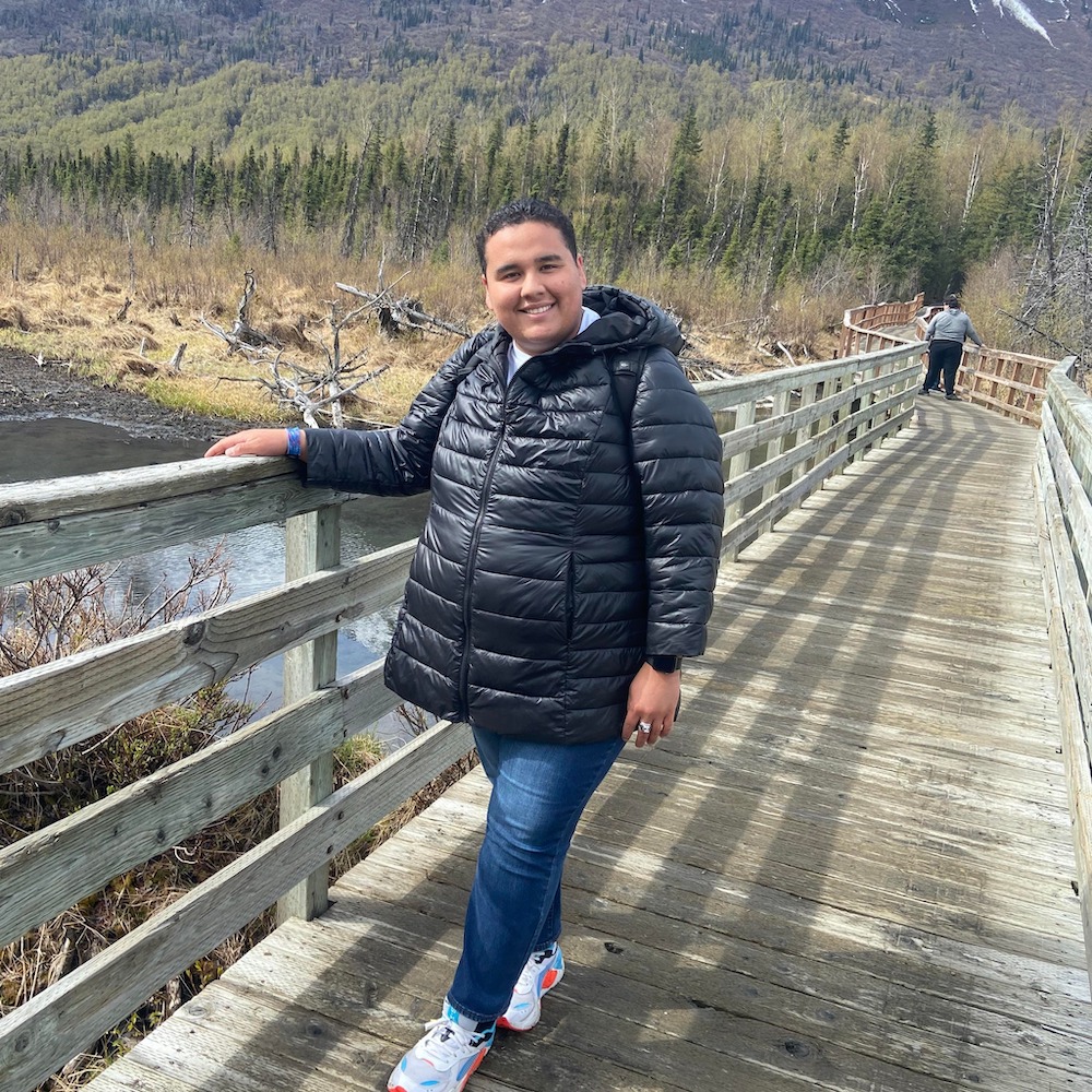 LCU student Robert Cantu stands on a bridge in the Alaskan countryside.