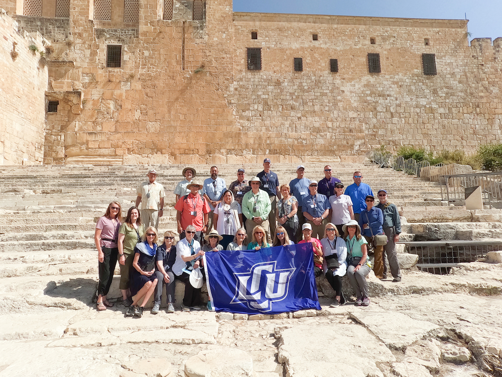 A group led by the Longs poses on the steps of some ruins