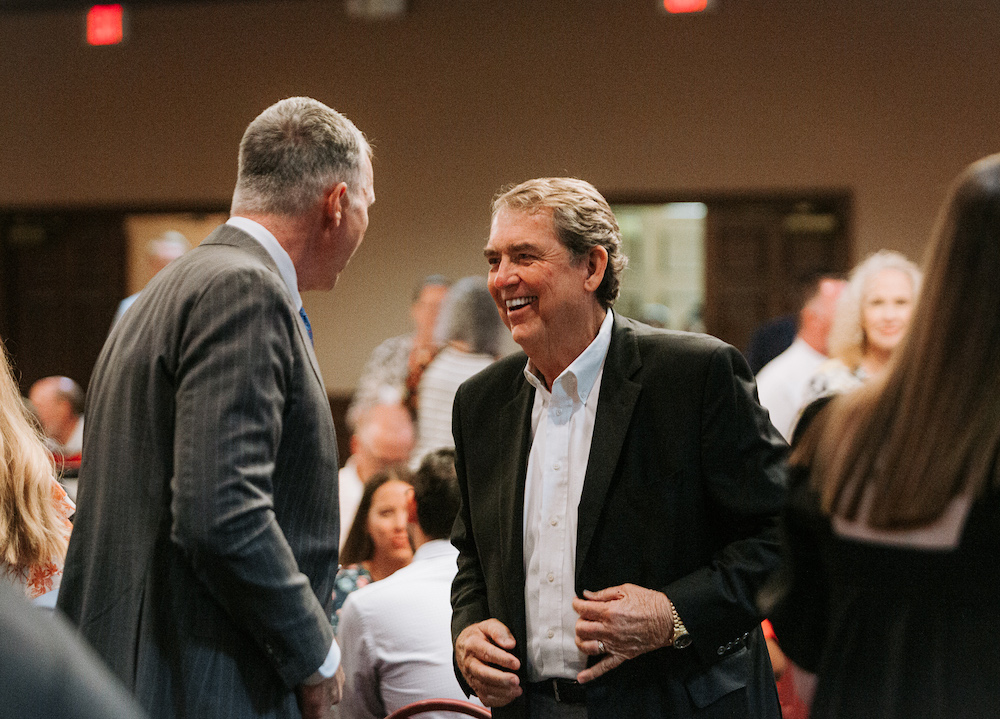 two men converse pleasantly at a formal evening dinner.