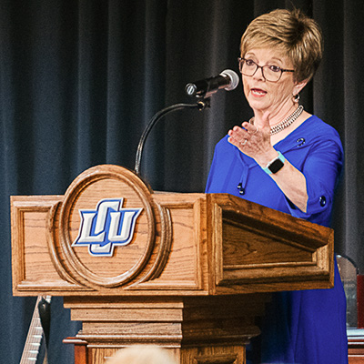 Emily Ratcliff speaking behind a podium on stage.