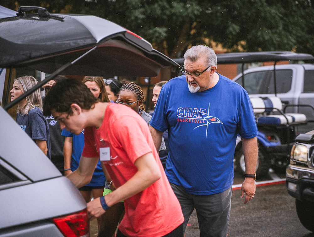Dr. Gallaher helps move new students into the dorm during a rainy morning