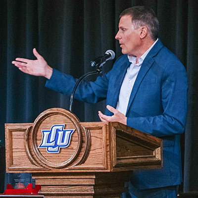 Russ Horn speaking on stage behind a podium.