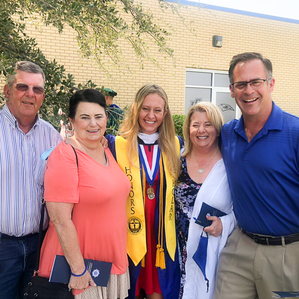 Skyler posing with her parents at her college graduation