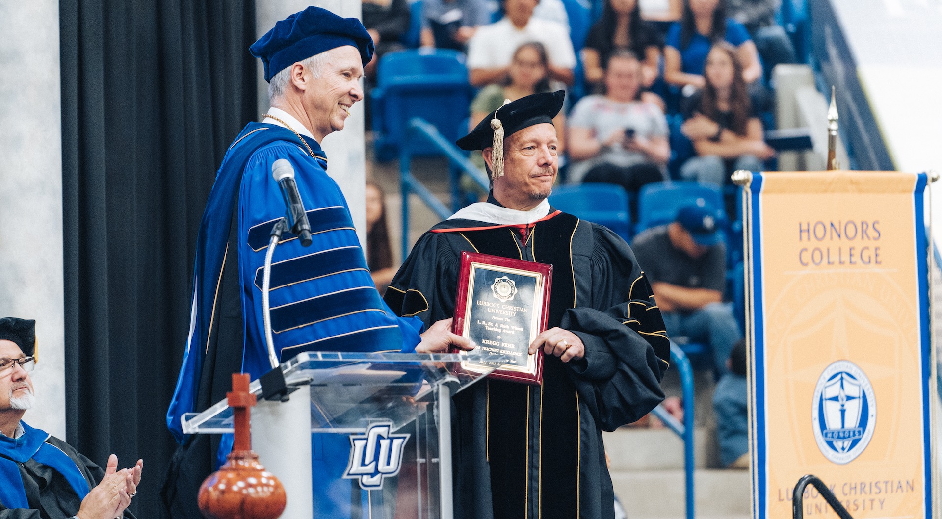 President McDowell giving Dr. Kregg Fehr his award on stage.