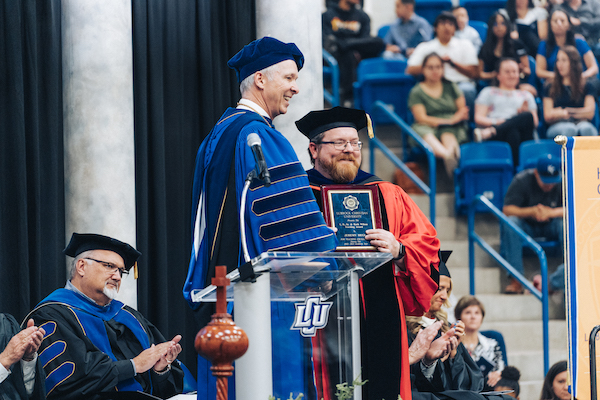 Dr. Jermey Hegi receiving his award from Dr. McDowell