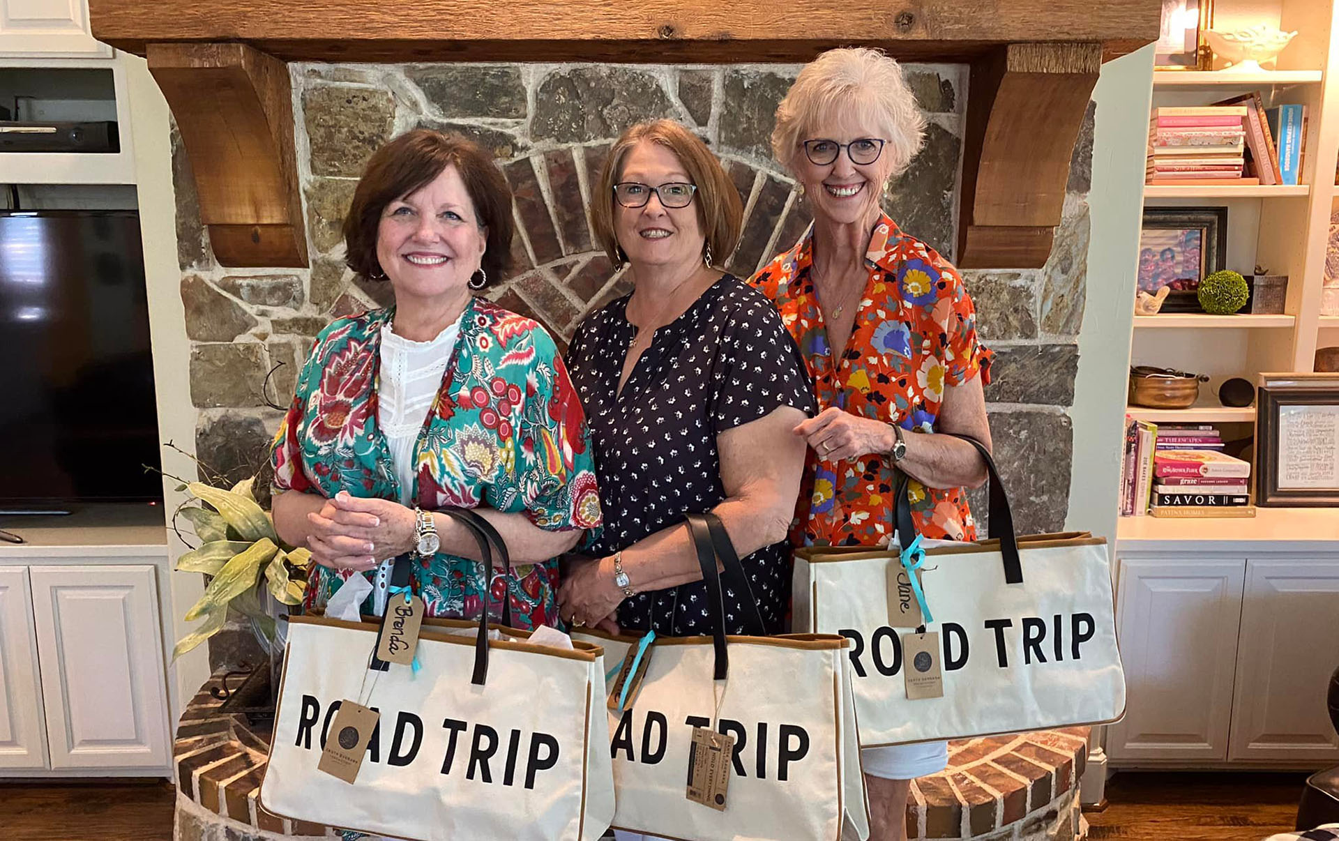 3 Alums with road trip bags on posing