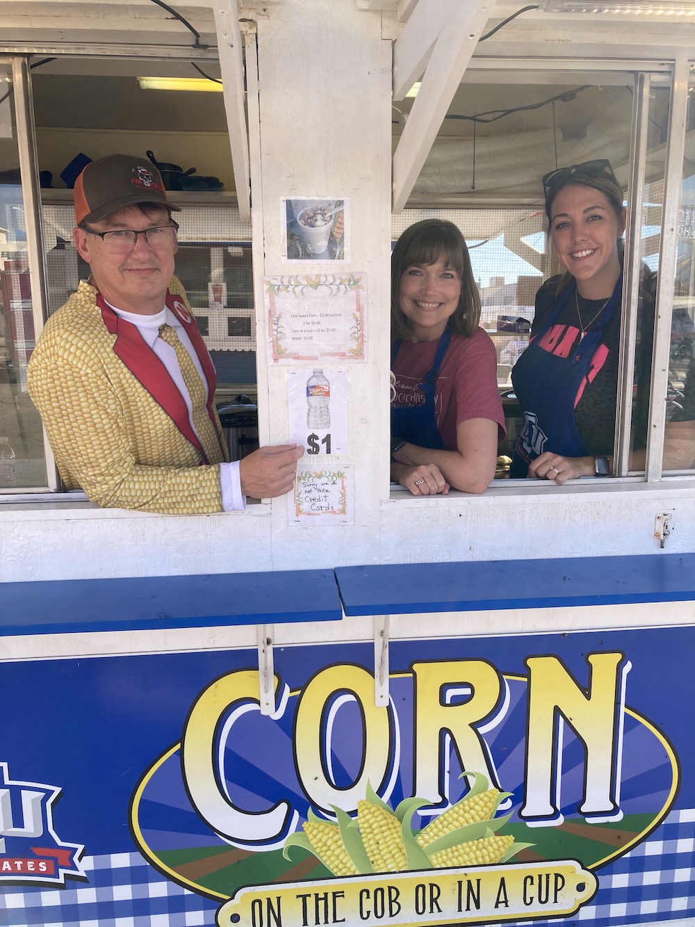 Terry and Traci Sparks and Katie (White) Baccus ('12) taking their turn running the corn booth.