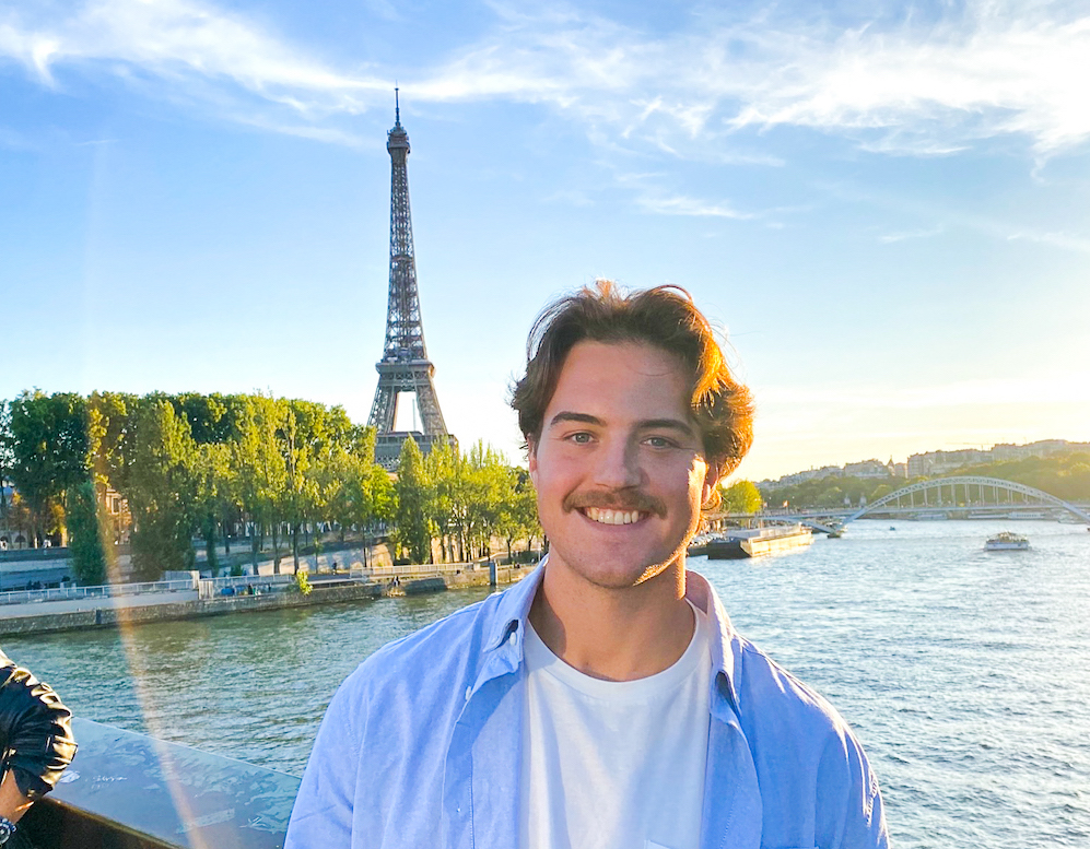 Connor Levy poses in front of the Eiffel Tower