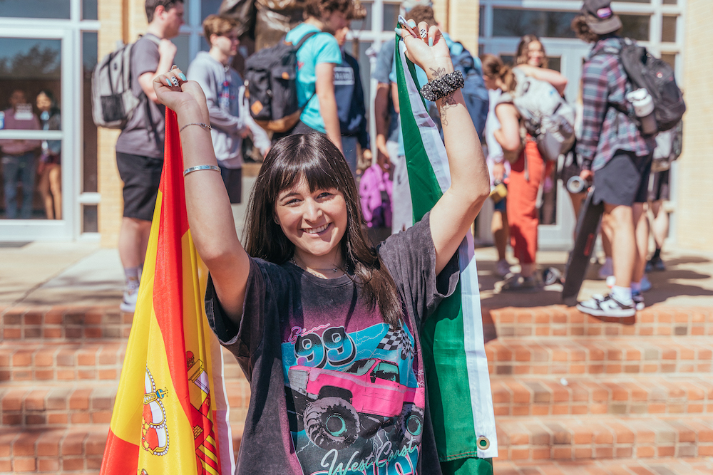 Ja'Nay Settles holding country flags over each shoulder