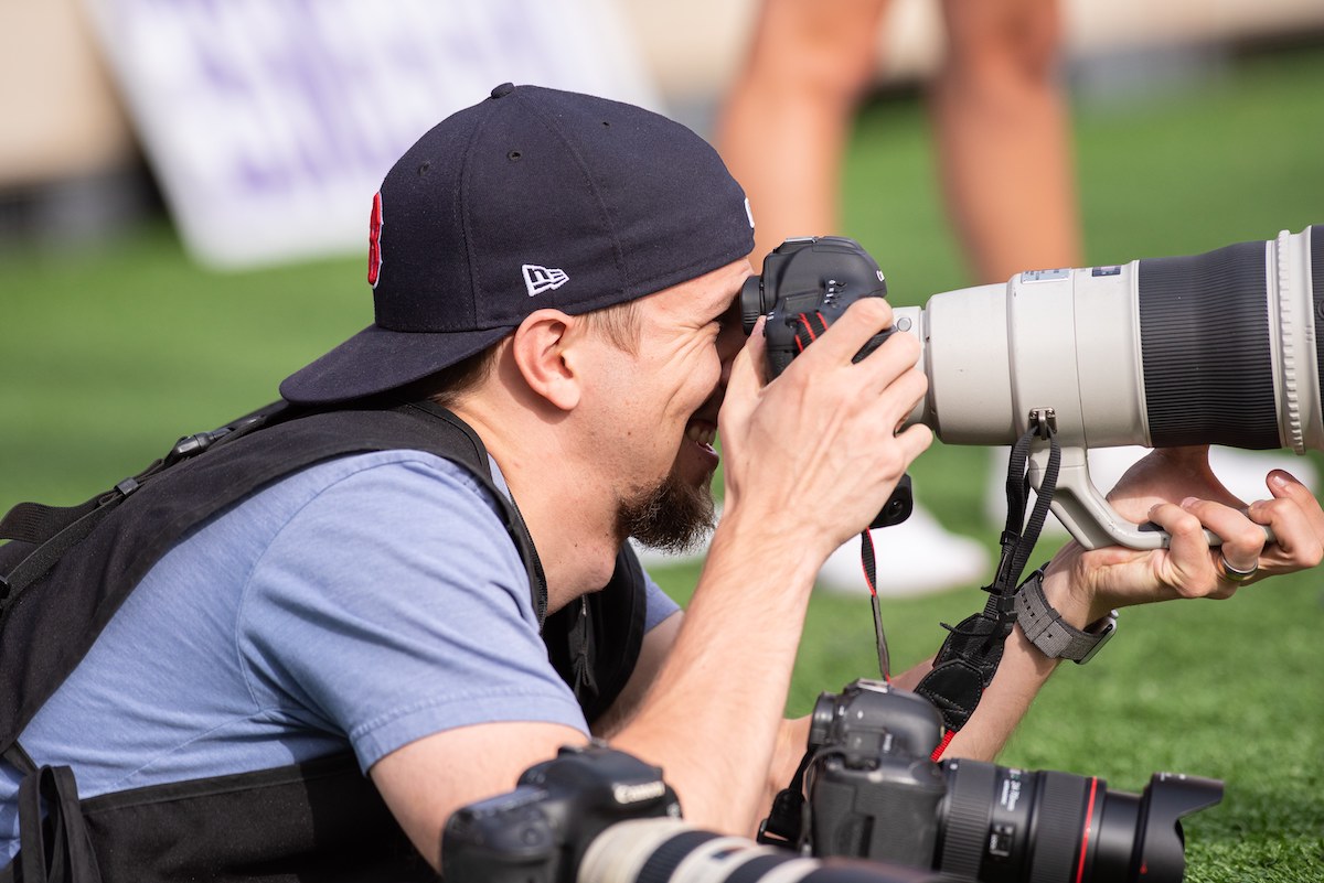 John taking a photo at a football game