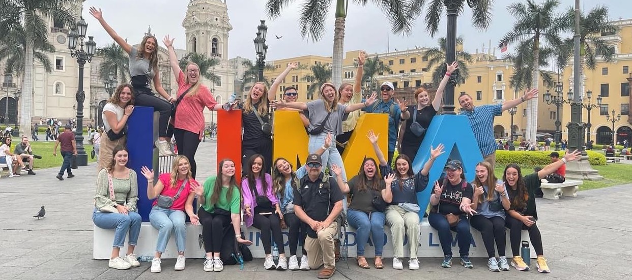 Students around a Lima Peru sign