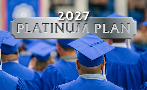 backs of students at commencement with 2027 Platinum Plan banner