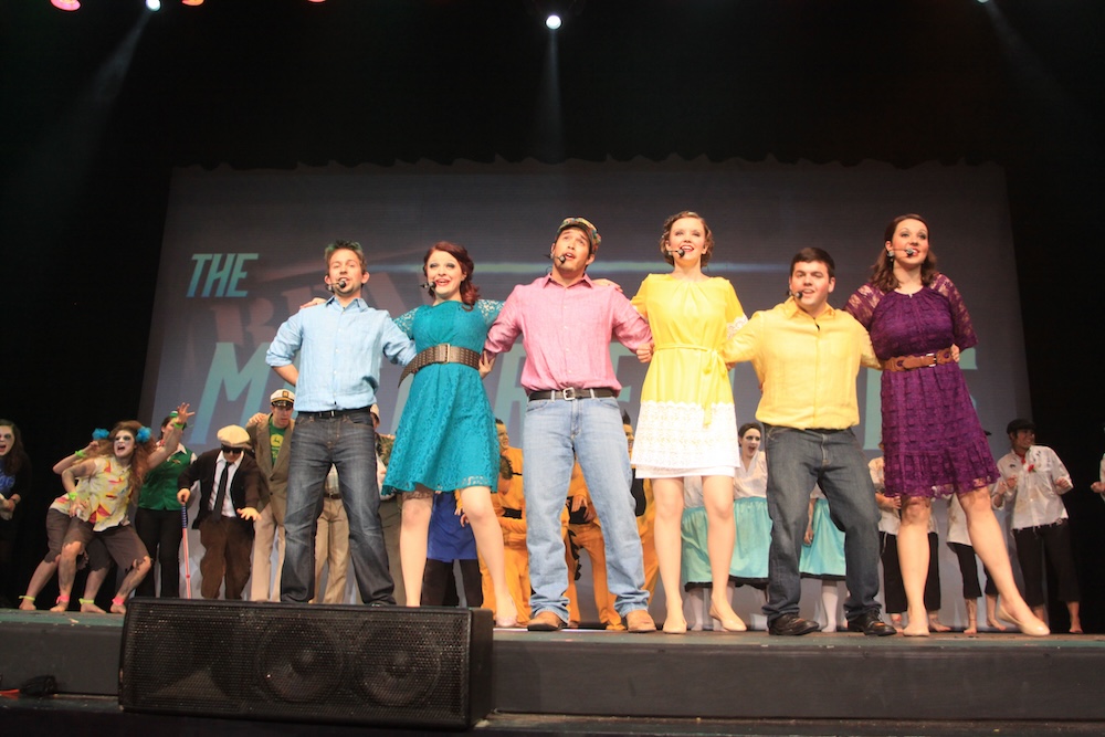 hosts and hostesses from 2013 singing final act on stage with social clubs behind them