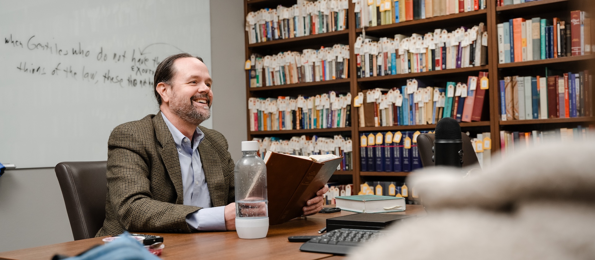 Dr. Michael Martin sitting at a table in a room full of books