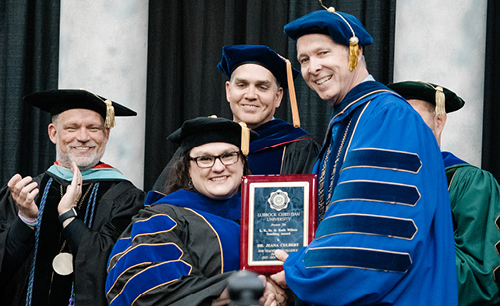 A LCU professor being handed a plaque but President McDowell