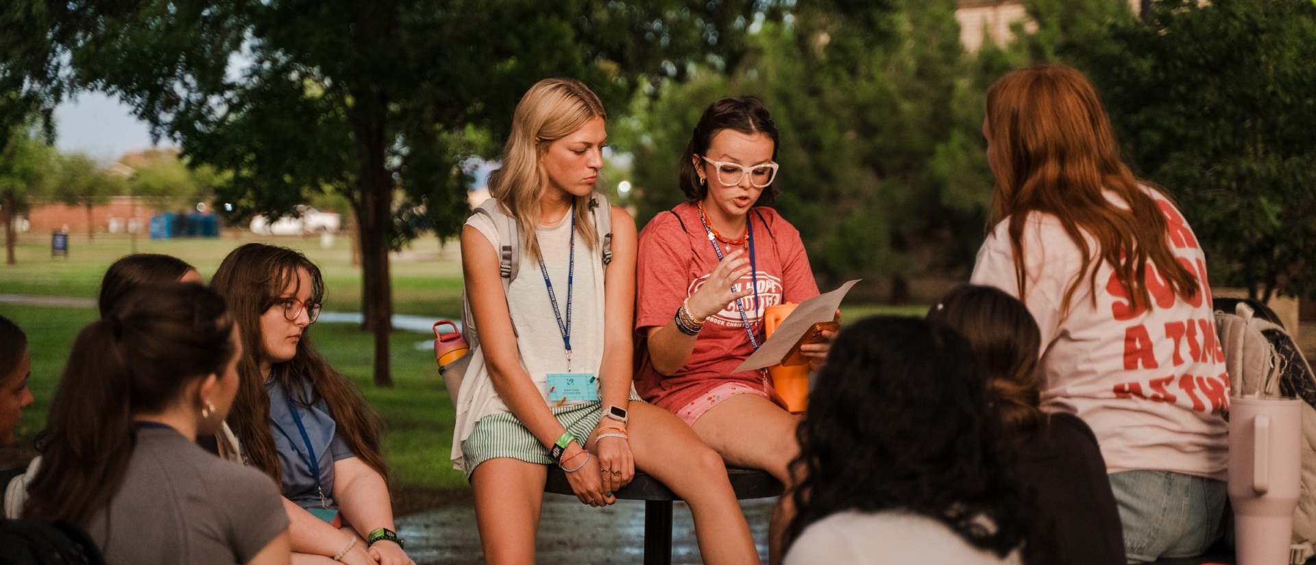 Two counselors surrounded by campers during a camp activity.
