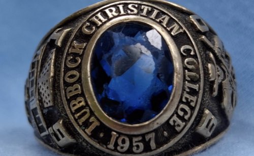 the front of a LCU ring that is silver and has a blue jewel