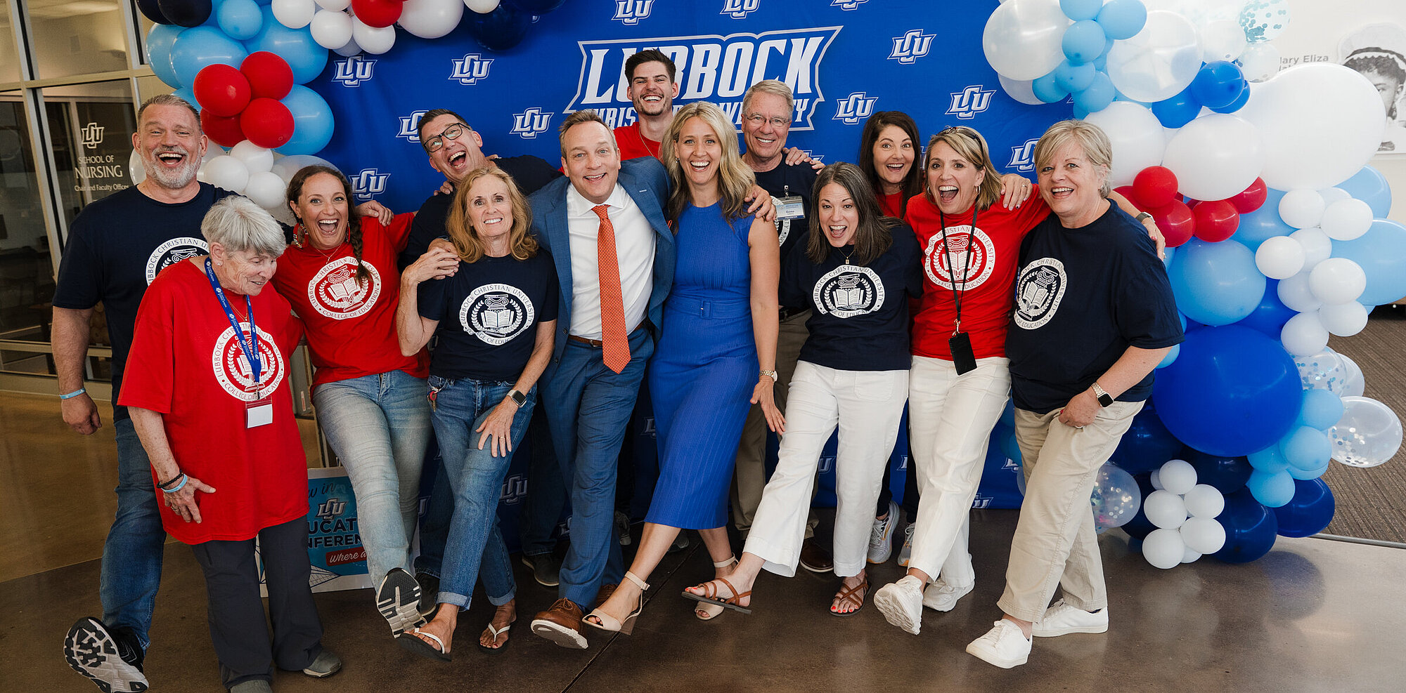 The education department and Aric Bostick in front a LCU backdrop with ballons