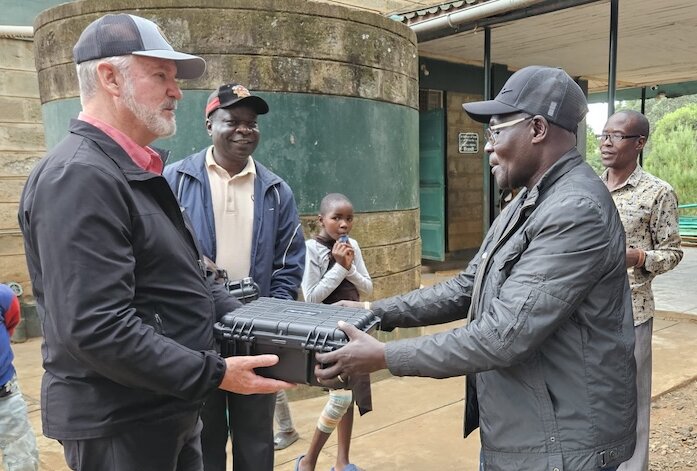 Shawn Tyler giving a solar media pack to man in south sudan