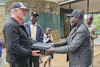 Shawn Tyler giving a solar media pack to man in south sudan