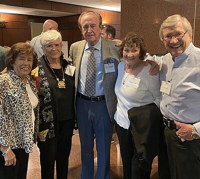 5 of the co founders of the school standing together at a reunion
