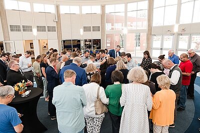 Josh Clem being surrounded in the welcome center being prayed over