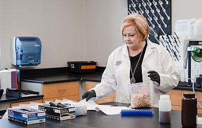 Dr. Marshall working at a table with a bag of peanuts in a lab
