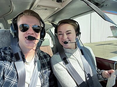 Jade with her husband in cockpit of small airplane