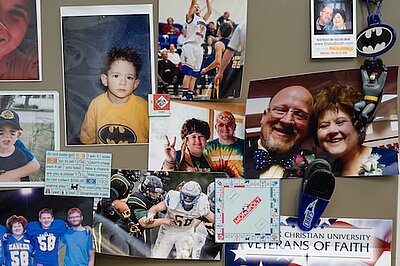 A cork board filled with family photos in Keiths office