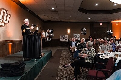 Lamar on stage speaking to the audience, view form the side