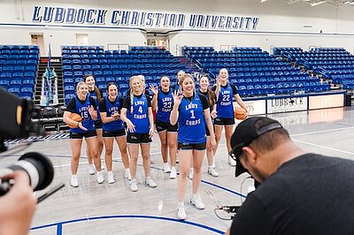 Video Crew capturing Kennedy with the basketball team behind her on the court