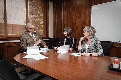 3 academic leaders sitting around a conference table