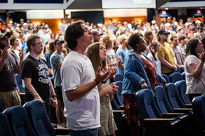 Students worshiping with raised hands during chapel