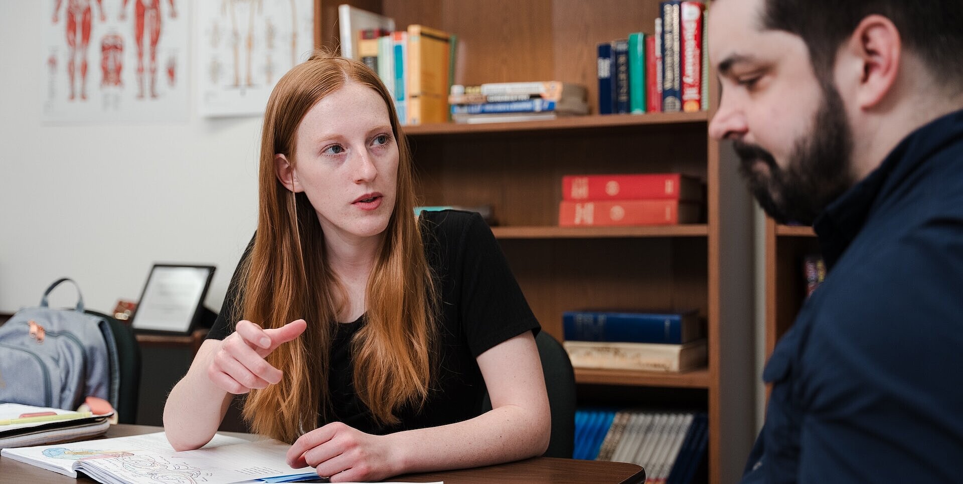 Student getting help understanding a subject at a table with a peer