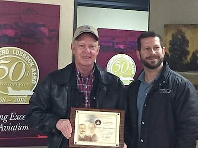 Tom holding an award plaque 