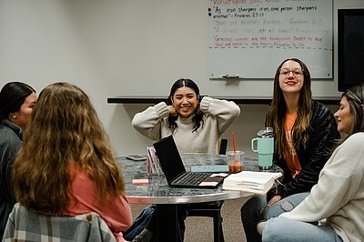 Students talking during a Friday small group in a classroom.