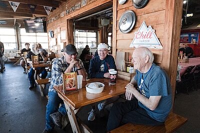 3 Alumni sub-t members sitting a table for lunch talking at rudys