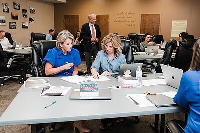 Two women reviewing a article at a desk