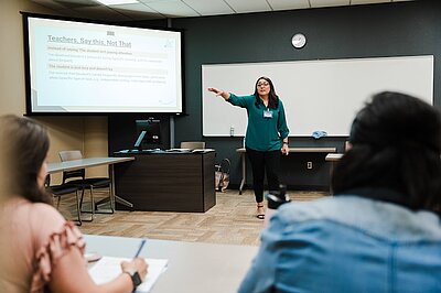 Professor teaching in front of class about teaching
