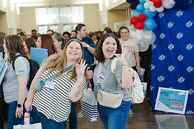 Two LCU Alumni giving the chap sign in the lobby area of nursing building