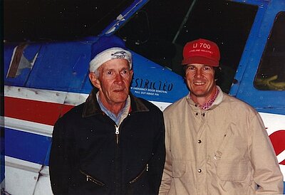 dudley standing next to a plane with his dad in the night time