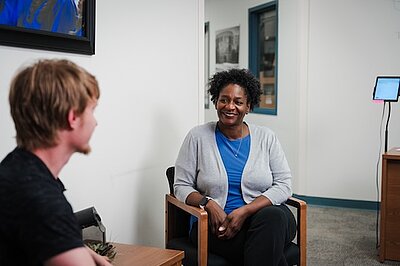Ingrid Johnson sitting talking with a student
