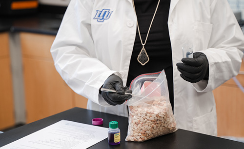 In a lab setting with someone in a lab coat working with a bag of peanuts