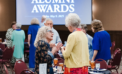 Two older women talking at the awards dinner in the baker