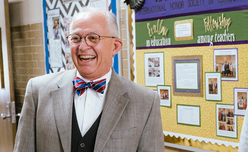 Sam Ayers laughing during a photo shoot in the education hallway