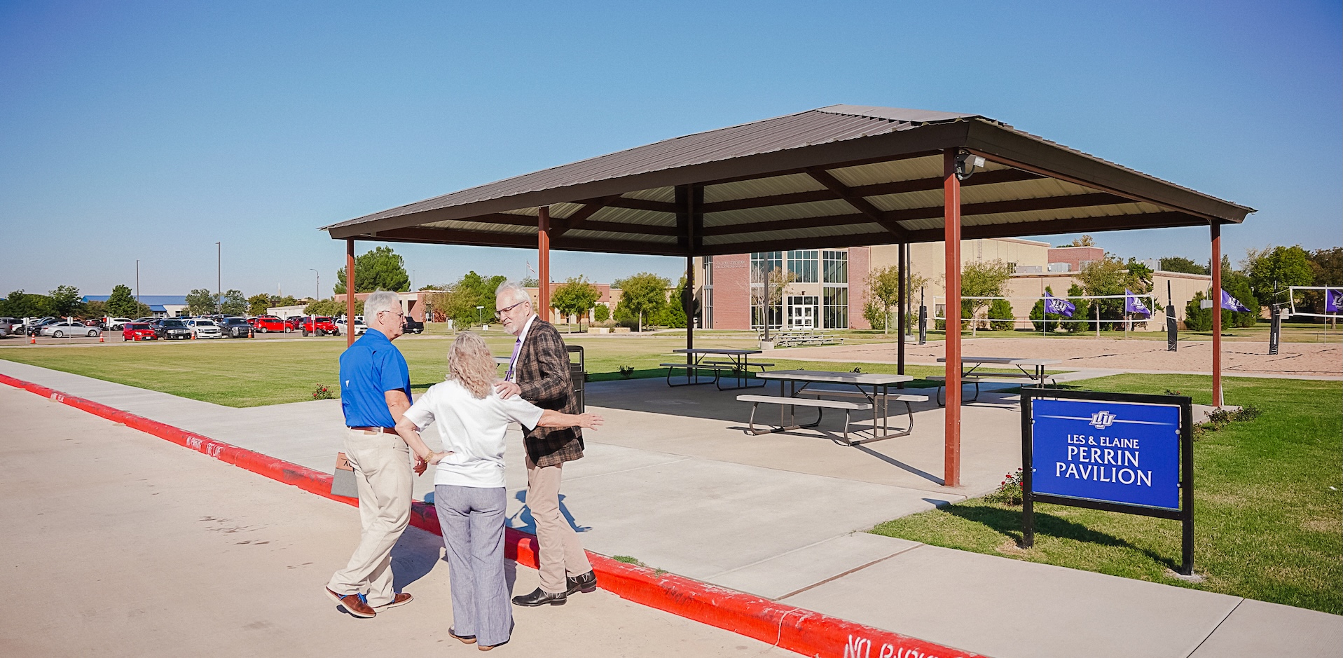 3 people talking in front of the pavilion structure