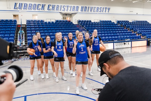 Video Crew capturing Kennedy with the basketball team behind her on the court