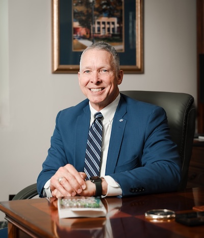President McDowell posing sitting at his desk