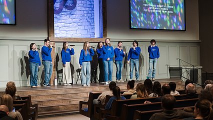 LCU's Best Friends singers performing on stage at a church