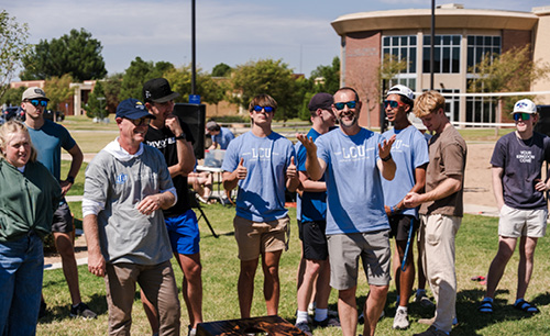 Bible professors playing corn hole with students